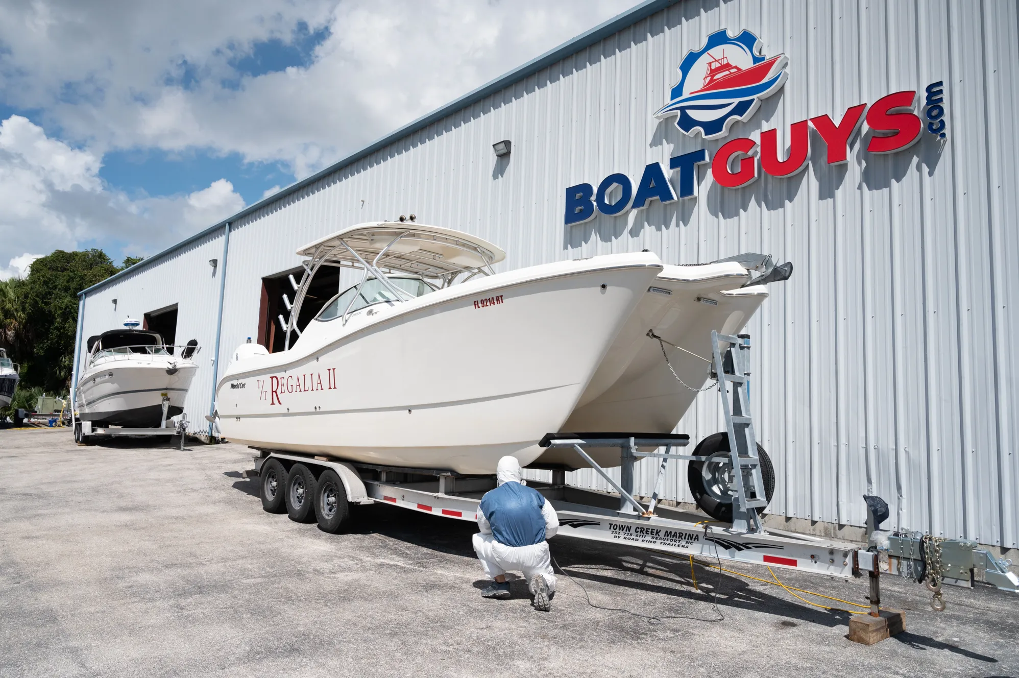 Boats on trailers and stands outside the Boat Guys shop