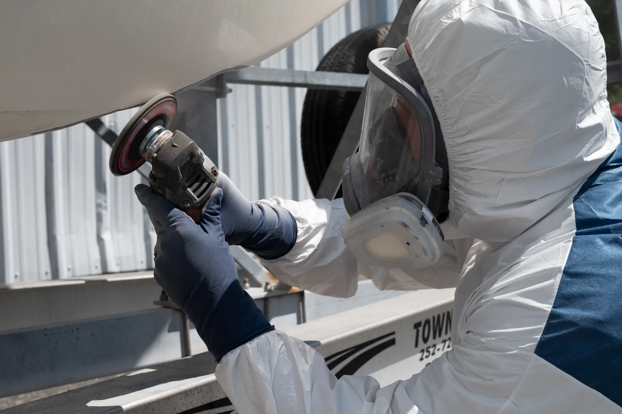 Close-up of a technician grinding a hull for repair