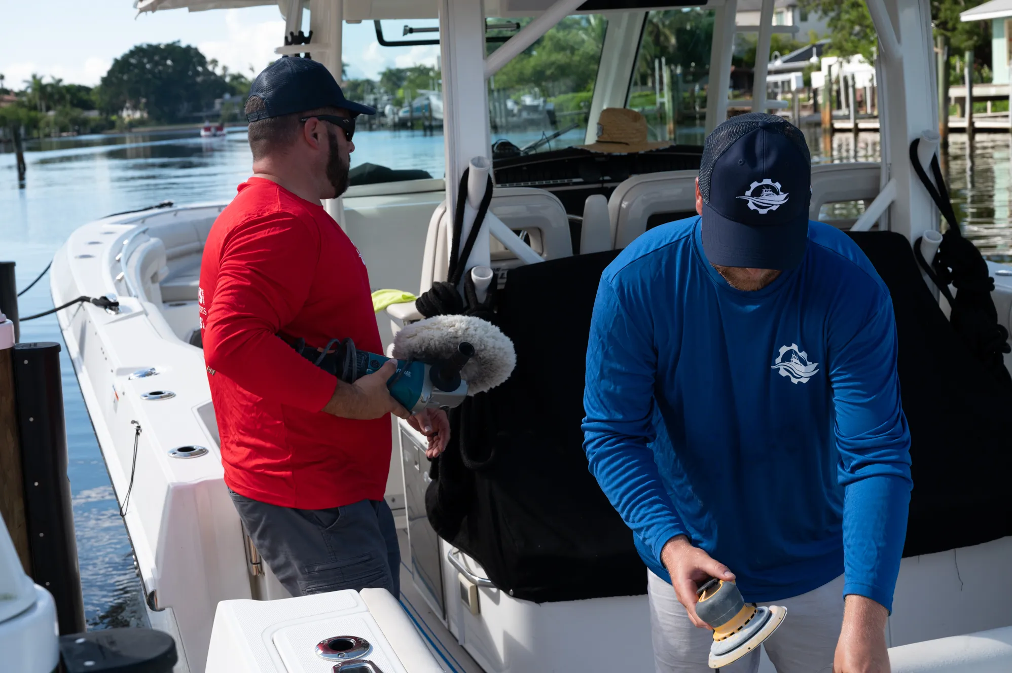 Two technicians polishing a center-console boat