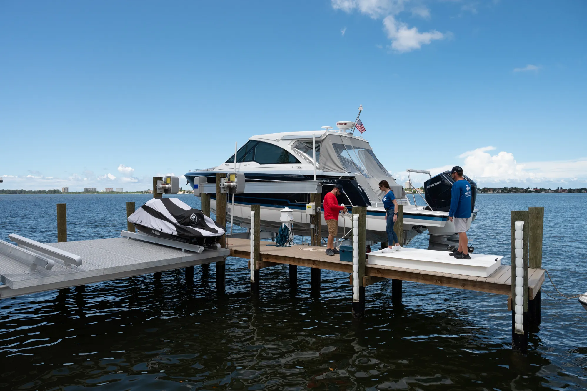 Two Boat Guys technicians servicing a cruiser on a dock lift