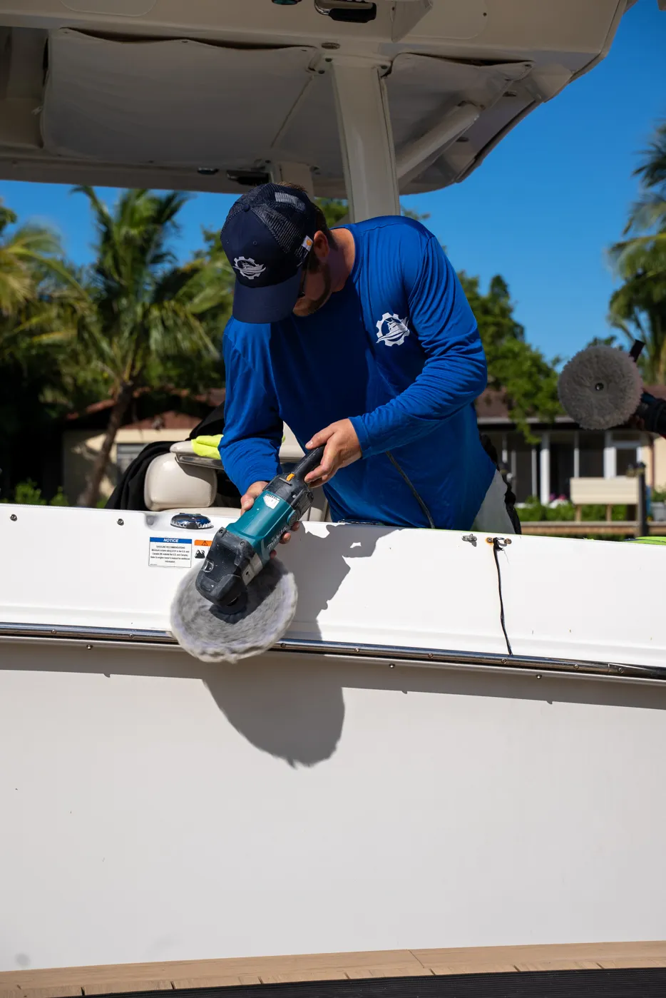 Polishing a boat gunwale with a wool pad