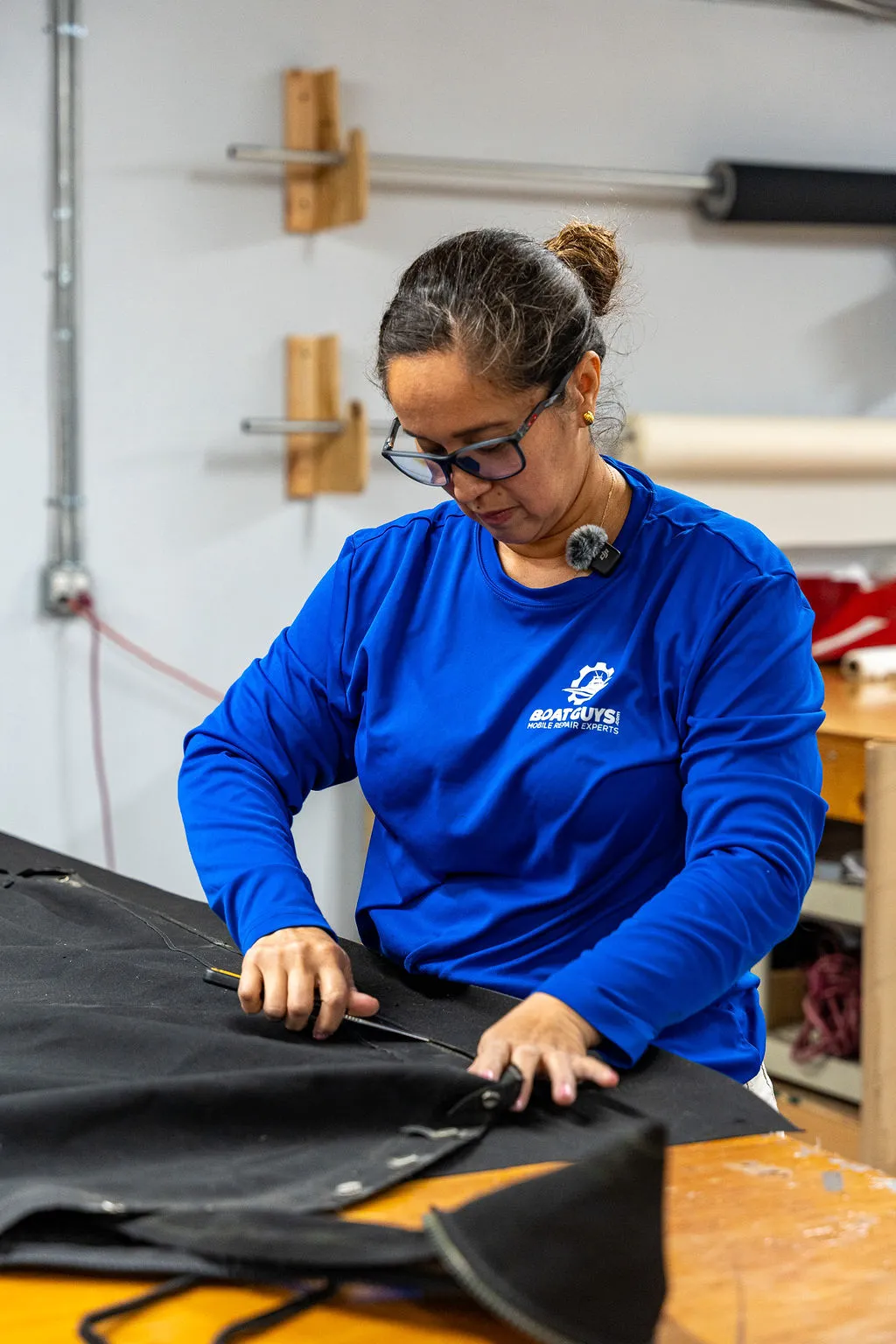 Boat Guys canvas maker cutting marine fabric on the workbench in the in-house shop