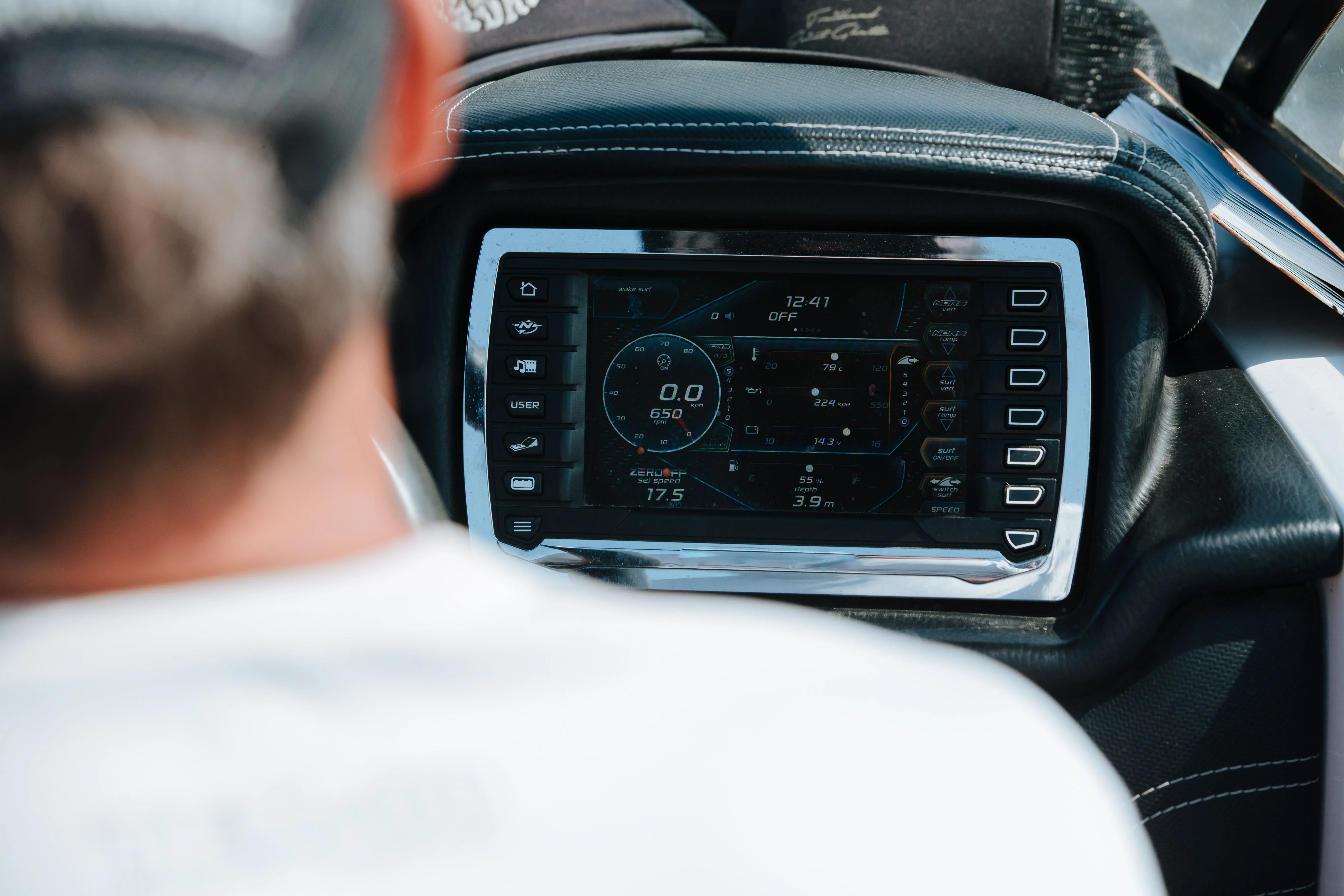 Boater at the helm using a large touchscreen chartplotter and multifunction display