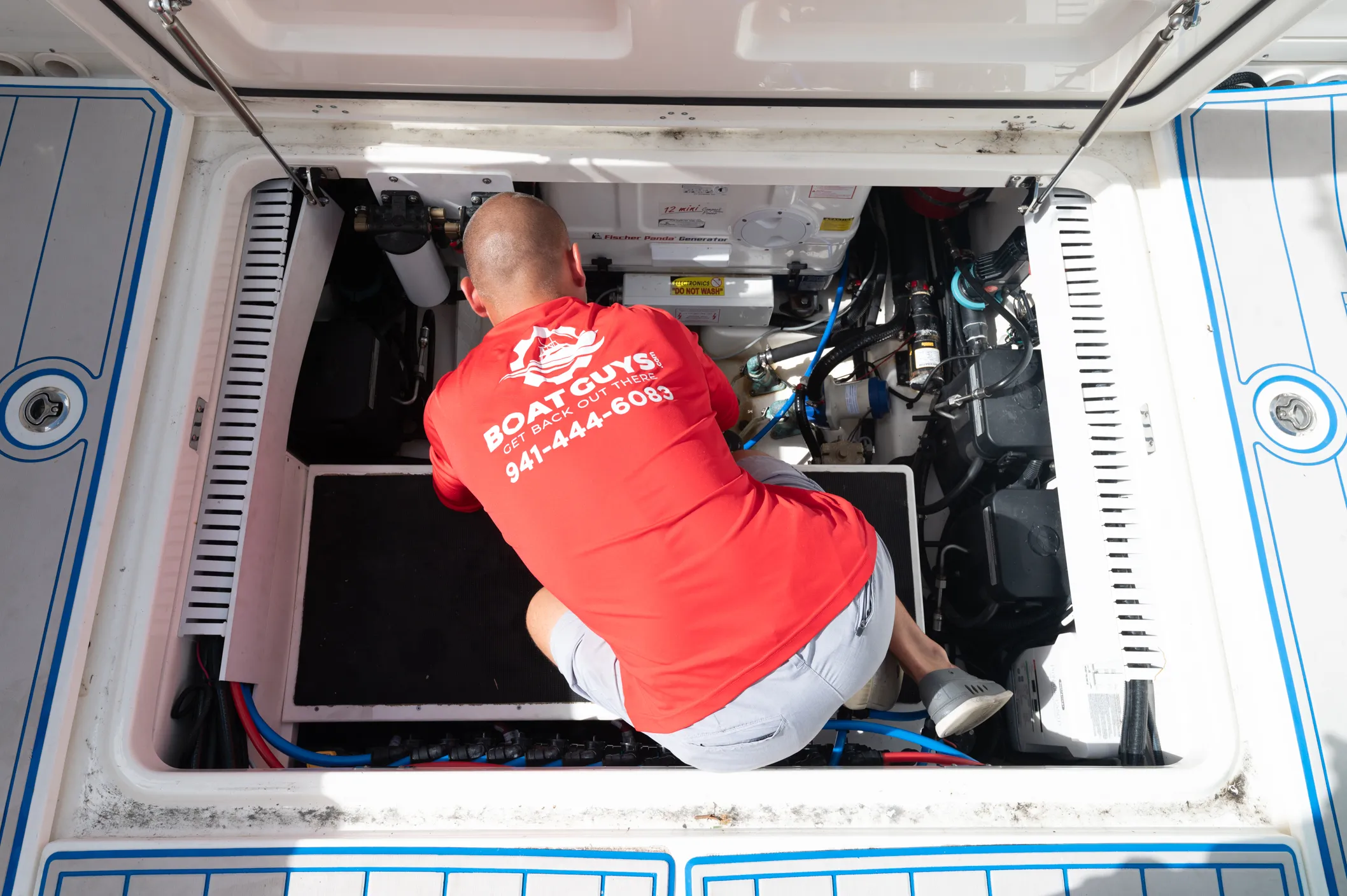 Boat Guys technician down in the bilge servicing a boat engine